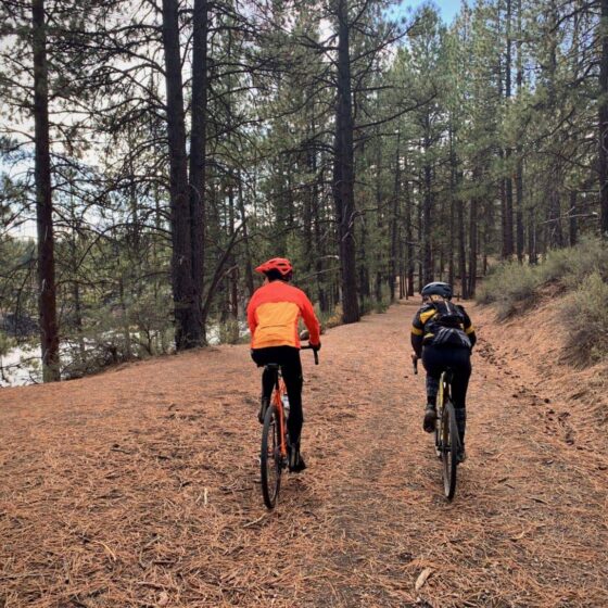 Gravel cyclists two abreast along Deschutes River.