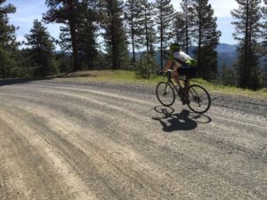 Single gravel bike rider on gravel road overlooking Ochocos.