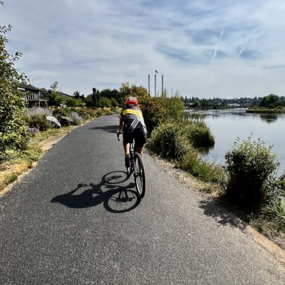 Riding bike path with the Old Mill smokestacks in the distance.