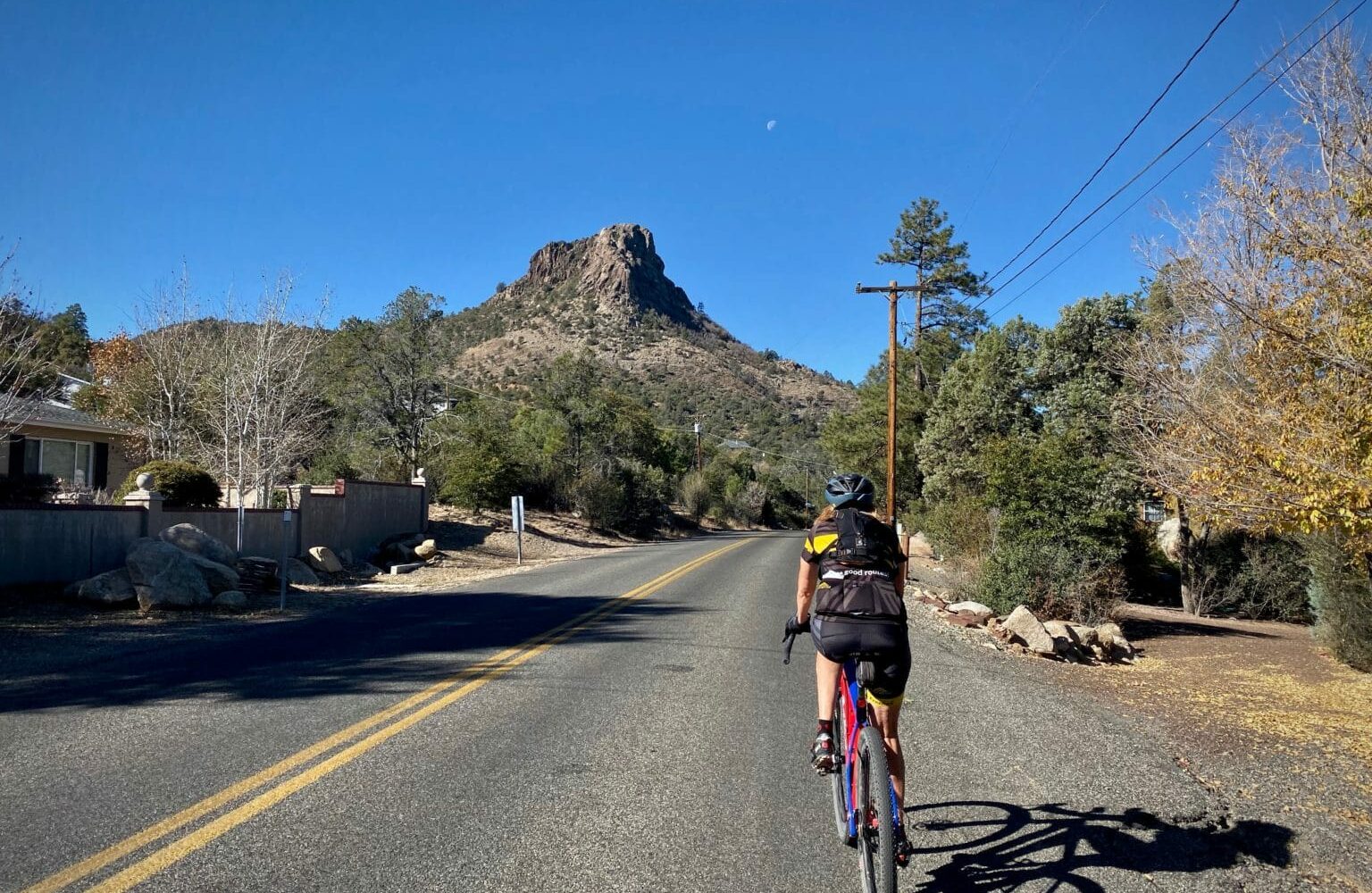 Cyclist riding towards Thumb Butte in Prescott, AZ.