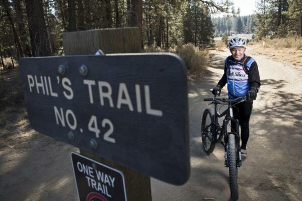 Phil Meglasson standing in front of Phil's trail sign