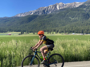 female cyclist on gravel road with mountain views in northeast oregon