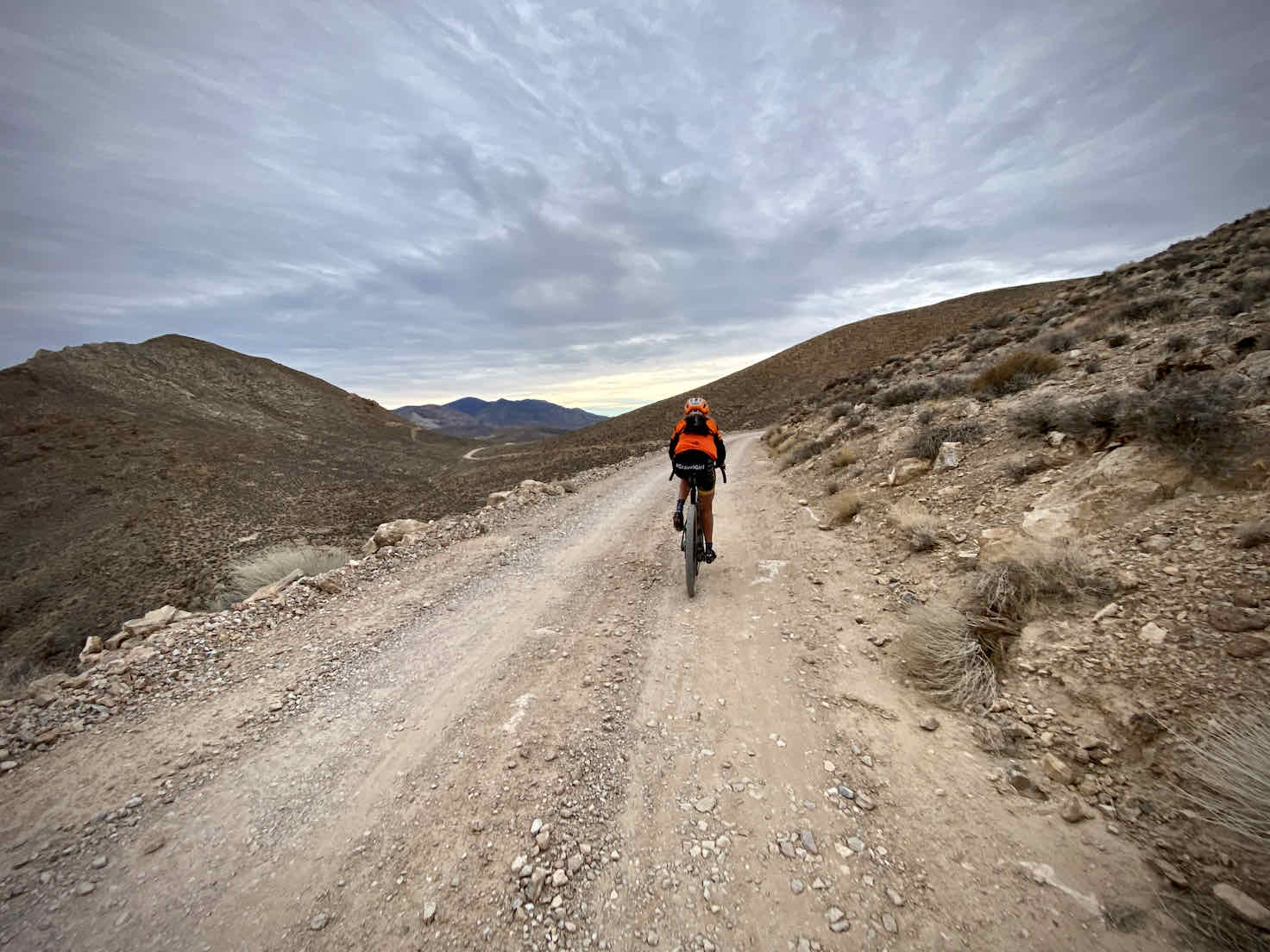 Cyclist negotiating the bumpy terrain along dirt road in Death Valley.