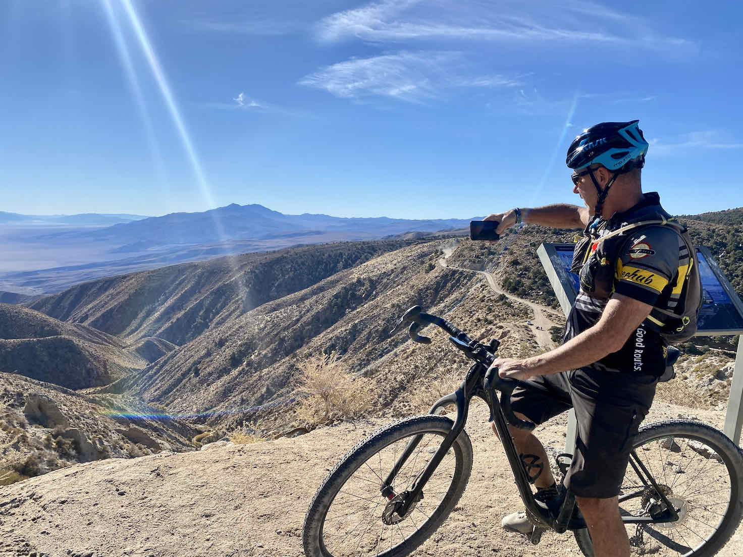 Cyclist taking a picture of the Panamint Valley from Hunter Mountain Road.