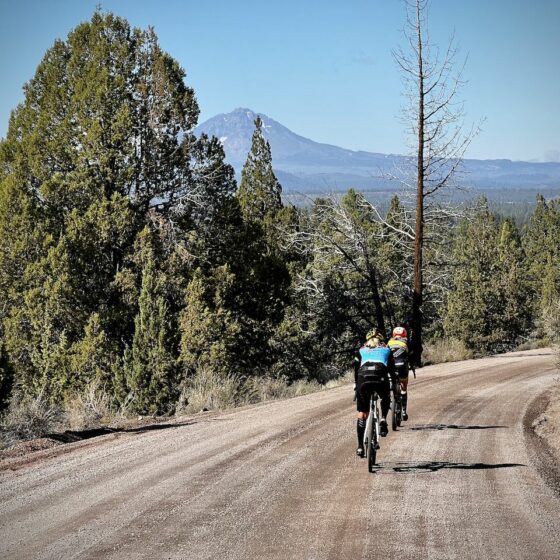 Two cyclist on road with North Sister in background.