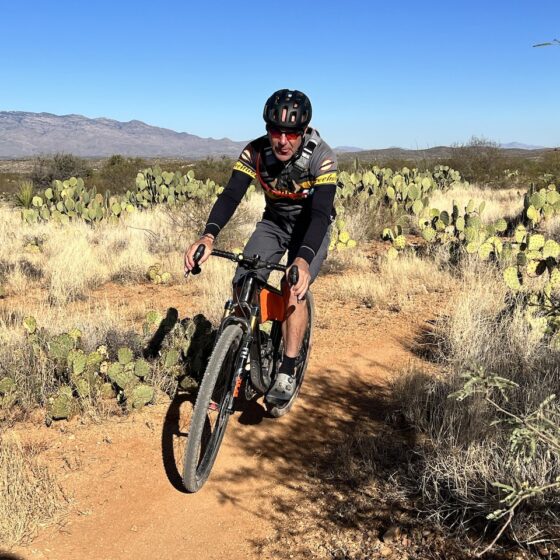 Gravel cyclist on single track with Prickly Pear cactus.