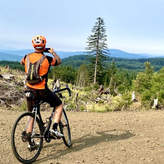 Cyclist taking picture on gravel road.