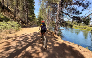 The Deschutes River with gravel cyclist on trail.