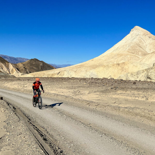 Gravel Cyclist riding along Twenty Mule Team road in Death Valley, California.