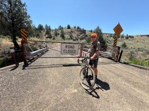 Cyclist in front of road closed gate.